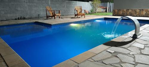 een zwembad met blauw water in een achtertuin bij Recanto da Luz de Órion in Pedra Bela