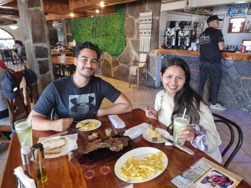 a man and a woman sitting at a table with food at HARRIS HOTEL Y RESTAURANTE in Licán Ray