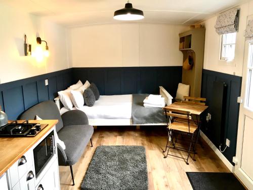 a small room with a bed and a table at Clay Bank Huts, Roseberry Shepherds Hut in Ingleby