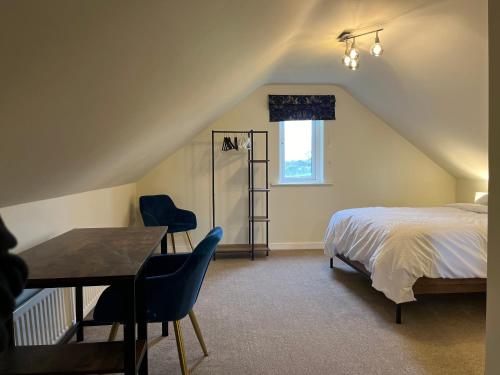 a bedroom with a bed and a table and chairs at Lisnevenagh Cottage in Ballymena