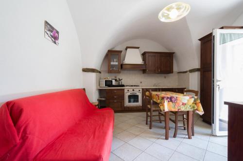 uma sala de estar com um sofá vermelho e uma mesa em Agriturismo del Ponte "pomelo" em Rialto