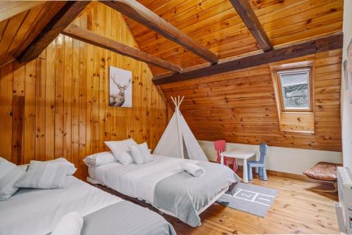 2 camas en una habitación con paredes de madera en Casa Rural ARIX en Sallent de Gállego