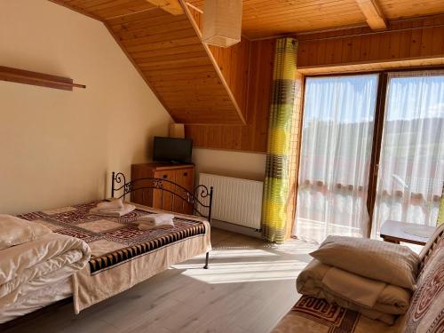 a bedroom with a bed and a large window at Endorfina in Muszyna