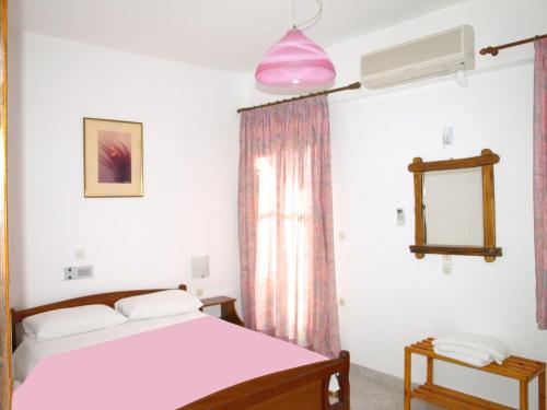 a bedroom with a bed and a pink lamp at Kastro Studios Apartments in Myrtos