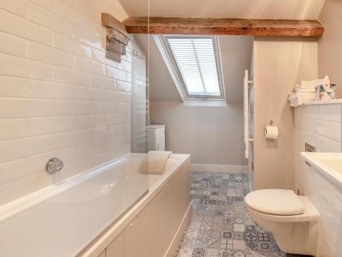 a bathroom with a tub and a toilet and a sink at Flat 5, The Lodge in York