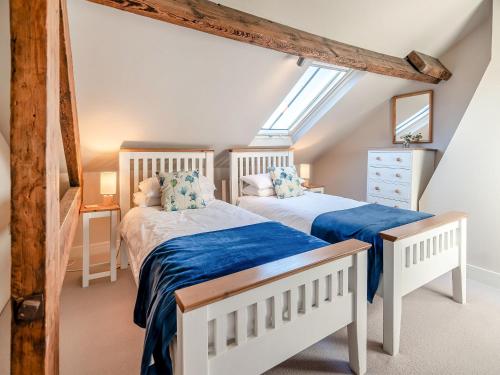 two beds in a attic bedroom with a skylight at Flat 5, The Lodge in York