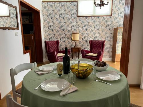 a table with a green table cloth and a bottle of wine at Dimora dei Seclì in Galatina