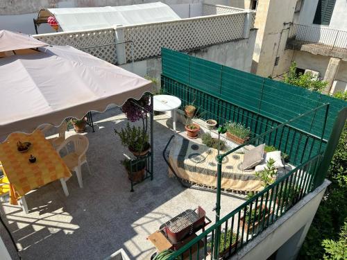 a balcony with an umbrella and a table and plants at Dimora dei Seclì in Galatina