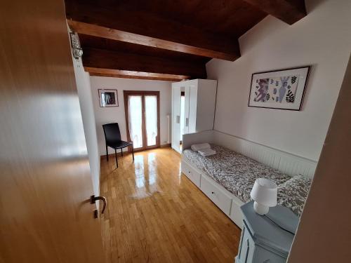 1 dormitorio con 1 cama y 1 silla en una habitación en Appartamento Luce-- 2 camere da letto--Centro storico--Parcheggio privato gratuito, en Lugo