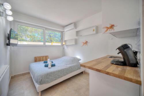 une petite chambre avec un lit et une cuisine dans l'établissement Jul - Studette - Croisette - VCA, à Cannes