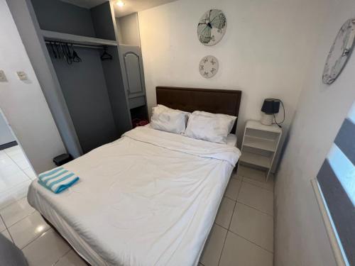 パングラオにあるGrande Villaの小さなベッドルーム(白いシーツ付きのベッド1台付)