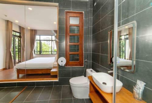 a bathroom with a toilet and a bed and a mirror at Villa Hero 5 bed roooms near beach, luxury swimming pool in Da Nang