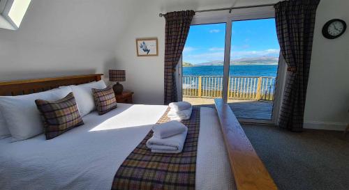 a bedroom with a bed with a view of the ocean at The BoatHouse in Sconser