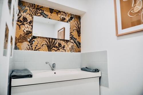 ein Bad mit einem Waschbecken und einem Spiegel in der Unterkunft Suite Lou _ Résidence Isaelle in Bray-Dunes