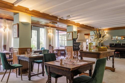 un restaurante con mesas, sillas y un piano en La Verniaz et ses Chalets, en Évian-les-Bains