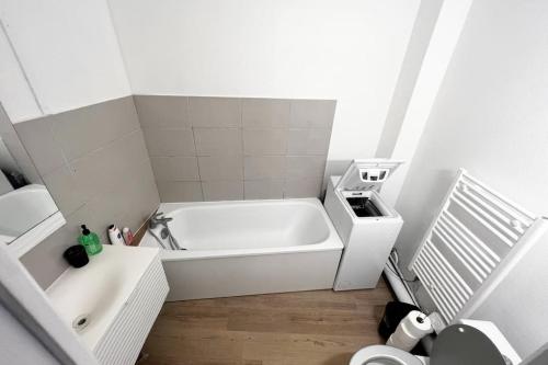 une salle de bain blanche avec une baignoire et un lavabo dans l'établissement Au P’tit Écureuil - Studio hypercentre Rouen, à Rouen