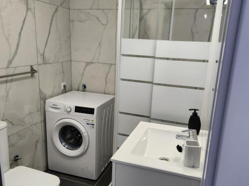 a bathroom with a washing machine and a sink at Bungalow del sol in Playa del Ingles