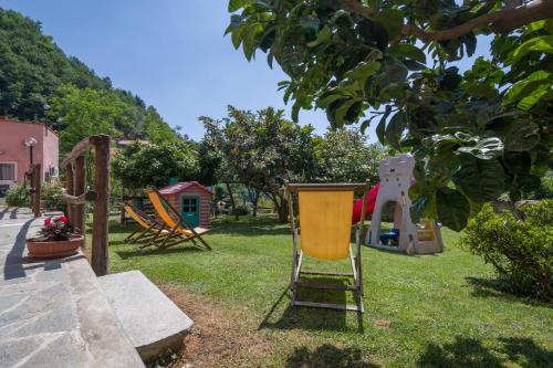 um parque infantil com uma cadeira amarela na relva em Agriturismo del Ponte "pomelo" em Rialto