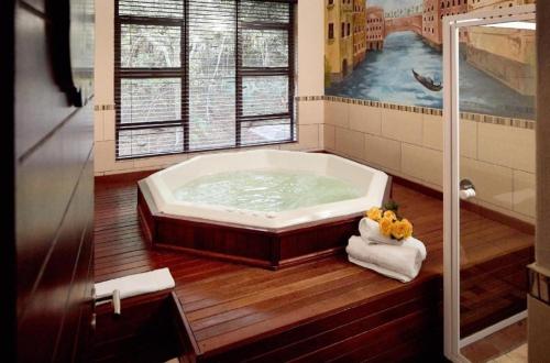un bagno con vasca e ampia finestra di Unit H011 Magalies Park Hartbeespoort a Hartbeespoort