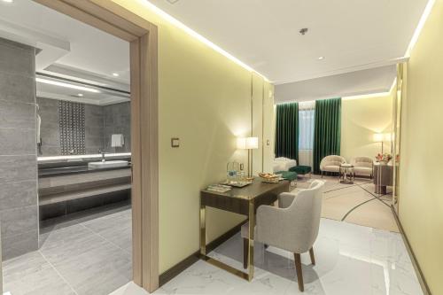 una camera d'albergo con scrivania e soggiorno di Green Park Hotel a Doha