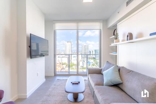a living room with a couch and a large window at Downtown Miami Condos by Lua Host in Miami