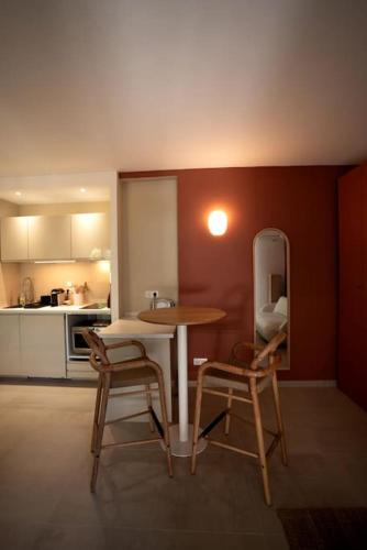 une petite cuisine avec une table et deux chaises dans l'établissement Appartement avec jardin proche mer, à Antibes