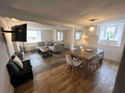 a living room with a table and a couch at Cosy two bedrooom cottage set in a Dorset village in Sturminster Newton