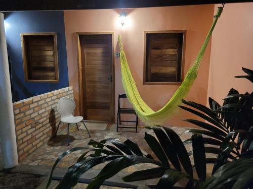 een kamer met een hangmat aan de muur bij Recanto das Arvores in Barreirinhas