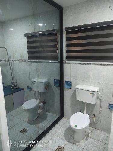 a bathroom with a toilet and a glass shower at Parandiapartment in Lagos