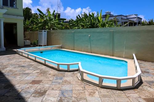 a large swimming pool with two rails in a yard at ibis Apartments - Ground Floor - Summersun Residence - Grand Baie, Pereybere in Grand Baie