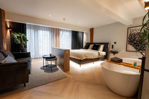 a bathroom with a bed and a tub in a room at Boetiekhotel Faan - NIEUW! in Ballum