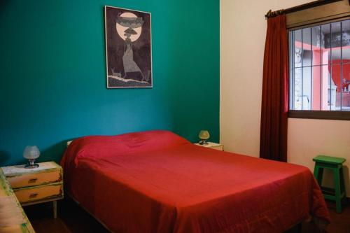 een slaapkamer met een rood bed en een groene muur bij Casa Corral Terra in Coronel Moldes