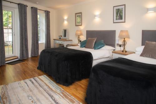 a hotel room with two beds and a television at The Garrandarragh Inn in Mullinavat
