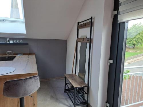 a room with a mirror and a chair next to a counter at Juliane`s Panorama-Domizil in Nemmersdorf in Goldkronach