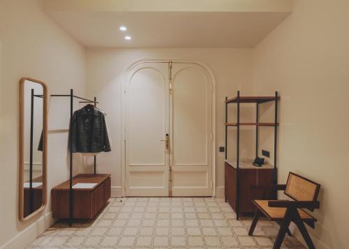 a room with a closet and a chair and a mirror at Casa Llimona Hotel Boutique in Barcelona