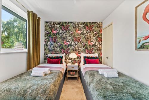 two twin beds in a room with a wallpaper at Beautiful House in Cambridge - Sleeps 6 in Milton