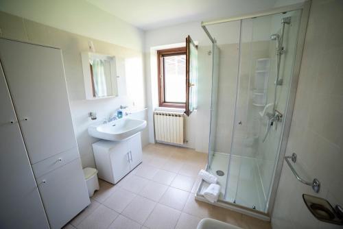 a bathroom with a glass shower and a sink at Cascina Pirondini in San Cassiano