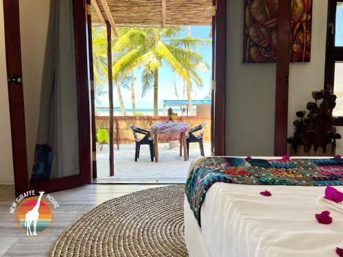 a bedroom with a bed and a view of the ocean at New Giraffe House in Vilanculos