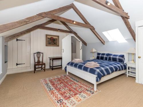 a bedroom with a blue bed and a table at Wdig Cottage - Qc1264 in St. Davids