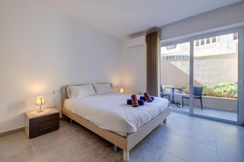 a bedroom with a bed with two teddy bears on it at Modern Maisonette in a Central Location in San Ġwann