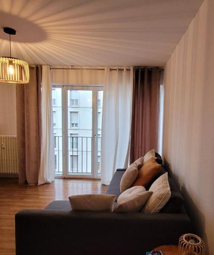 un salon avec un canapé et une grande fenêtre dans l'établissement 2p lumineux au Cœur de Strasbourg, à Strasbourg