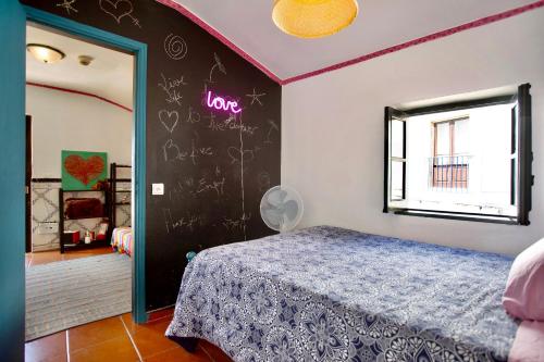 a bedroom with a bed and a chalkboard on the wall at Love Temple in Ericeira