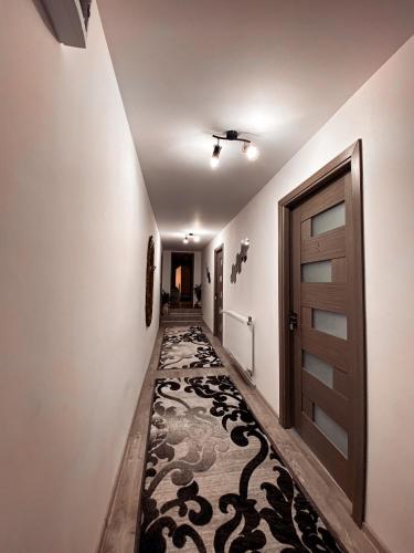 a hallway with a carpeted floor and a door at Casa Irina in Mănăstirea Humorului