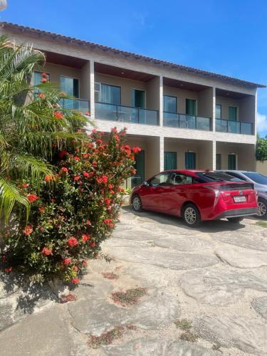 un coche rojo estacionado frente a un edificio en Pousada Bon Vivant, en Cabo Frío