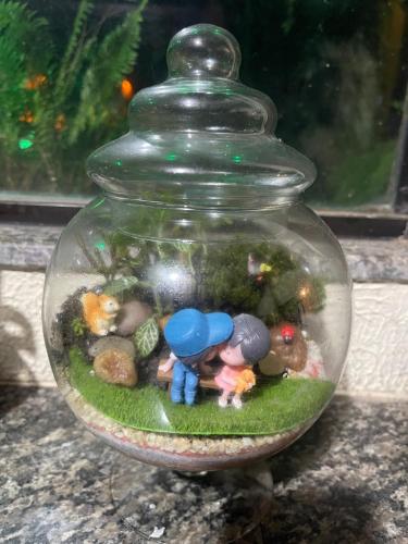 a glass jar with figurines of people and rocks in it at Pousada Bon Vivant in Cabo Frio