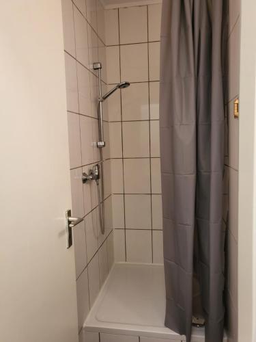 W łazience znajduje się prysznic z zasłoną prysznicową. w obiekcie SP Hotel Mettmann w mieście Mettmann