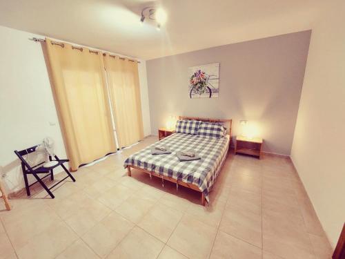 a bedroom with a bed and a chair in it at Casa Bella Vista - pool - WiFi in Caleta De Fuste