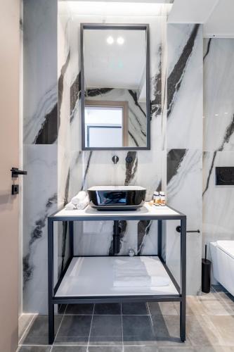 a bathroom with a sink and a mirror at ERMOU 40 SUITES in Athens