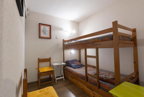 Mały pokój z łóżkiem piętrowym i krzesłem w obiekcie Appartement Le Bois de Marie w mieście Barèges