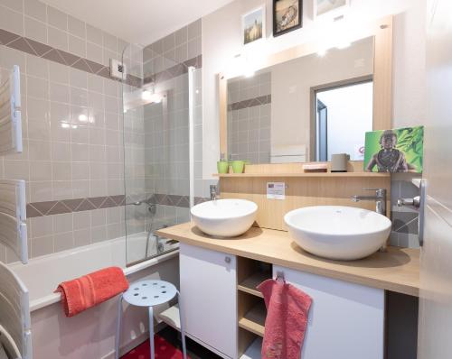 Baño con 2 lavabos y espejo en Appartement Le Bois de Marie en Barèges